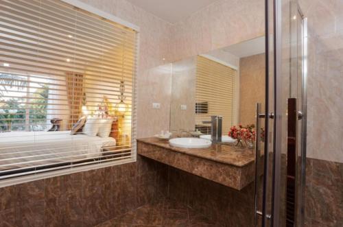 万象Xaysomboun Hotel & SPA的一间带水槽、床和镜子的浴室