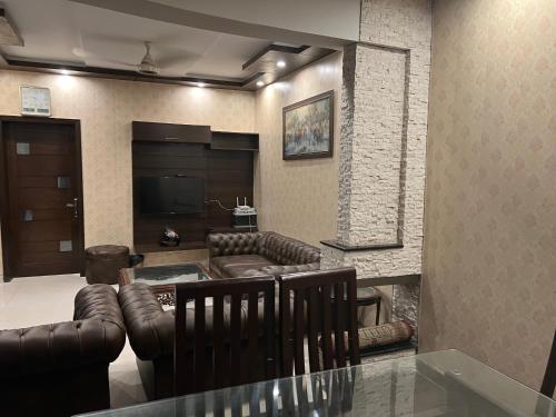 拉合尔Royal Three Bed Room Full House Dha Phase 6 Lahore的客厅配有皮革家具和平面电视