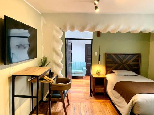 库斯科Apartamentos Montes的一间卧室配有一张床、一张桌子和一把椅子