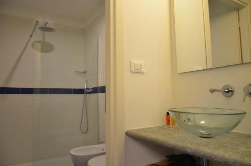 都灵维托里奥广场套房的浴室设有水槽和吧台上的玻璃碗
