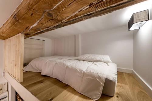 卡威尔奎Studio proche cité internationale的一间卧室设有一张带木制天花板的大床