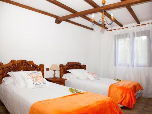 Villanueva del CondeAlojamiento Rural Villanueva del Conde的卧室设有两张床,拥有白色的墙壁和木制天花板