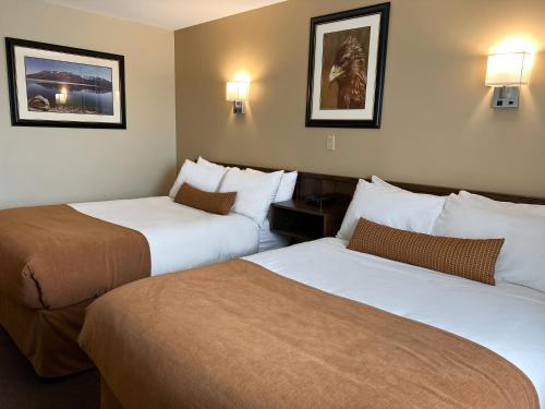 Carmacks卡马克斯酒店的两张位于酒店客房的床,墙上有灯
