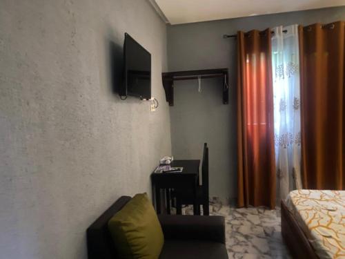 杜阿拉Sunrise Center Bonapriso 104的客房设有桌子、椅子和书桌。