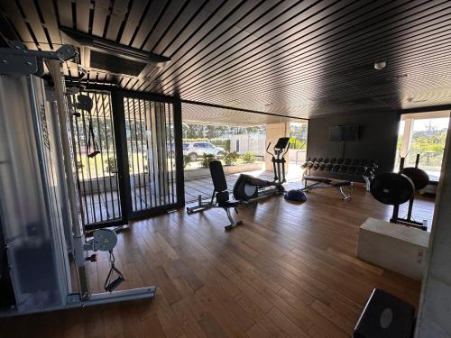 蒙得维的亚Apartamento frente al lago的铺有木地板的健身房配有跑步机和椅子