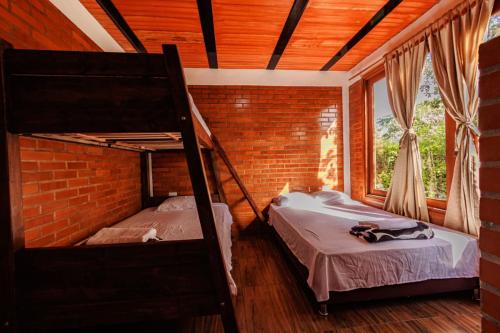 瓜杜阿斯VILLA JULIETA CABAÑA 1的一间卧室设有两张双层床和砖墙