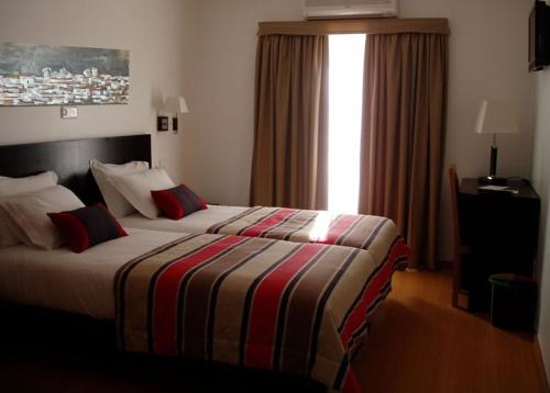 韦迪堡埃斯特瓦酒店的酒店客房,配有带条纹毯子的床