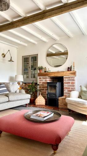 GrundisburghCharming 3 bedroom house in Woodbridge area的客厅设有壁炉和红色地毯。