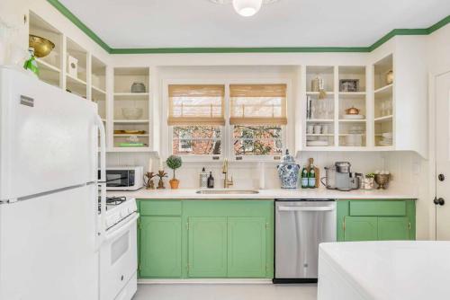 查尔斯顿The Grand Millennial in Downtown Charleston的厨房配有绿色橱柜和白色冰箱
