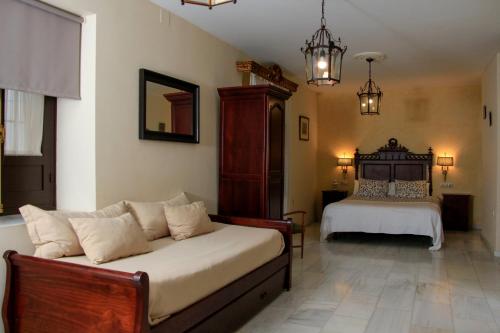科尔多瓦Apartamentos Medina Qurtuba的一间卧室配有一张床和一个沙发
