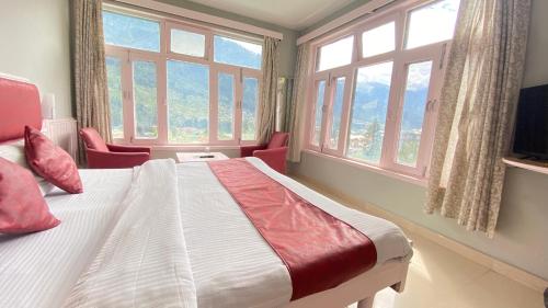 马拉里Hotel Mountain Meadows的一间卧室配有一张带窗户的大床