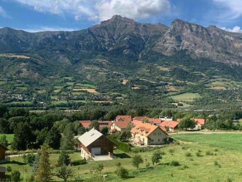 圣雷热雷梅累兹Studio confortable et chaleureux, vue magnifique的山丘上以山为背景的房子