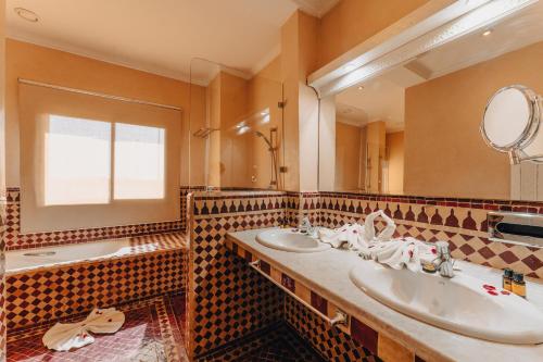 马拉喀什Palace Jena的浴室设有2个水槽、镜子和浴缸。