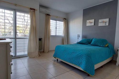 科尔多瓦Casa Pascal, Bº Villa Belgrano的一间卧室配有一张带蓝色棉被的床
