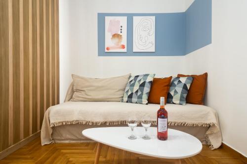 雅典KUKAKI ESTATE 2的客厅配有沙发和桌子上的两杯酒
