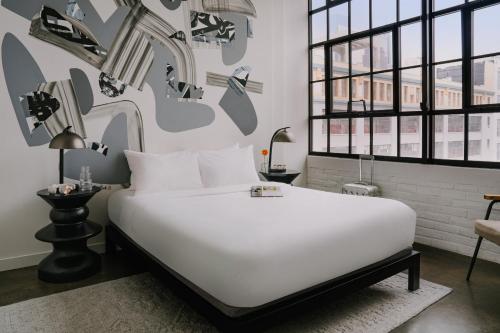 费城Sonder The Heid的卧室配有一张白色大床,墙上挂着鞋子