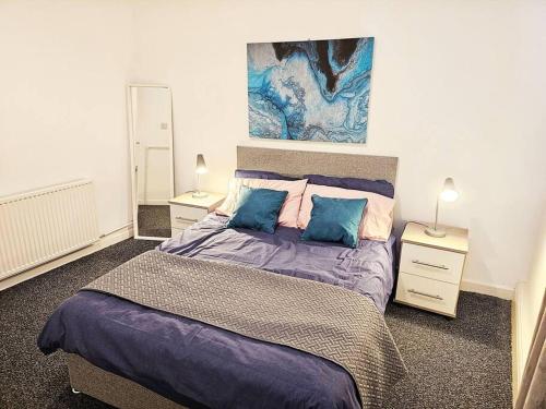 登顿Denton, Manchester的一间卧室配有一张带蓝色枕头的大床