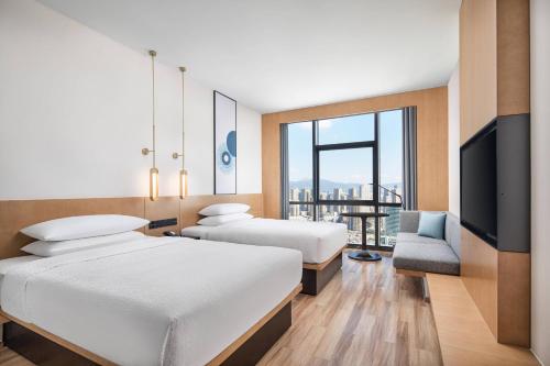 昆明昆明新迎万枫酒店的酒店客房设有两张床和电视。