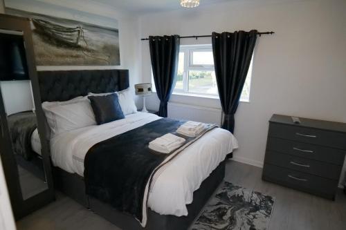 米尔顿凯恩斯Giomakay luxury Rooms Milton Keynes的一间卧室设有一张大床和一个窗户。