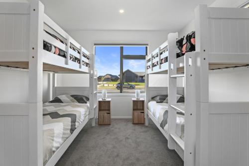 陶波Wai Escape - Taupo Holiday Unit的带窗户的客房内的两张双层床