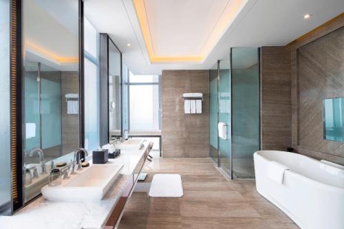 大厂廊坊潮白河喜来登酒店的一间带三个盥洗盆、浴缸和镜子的浴室