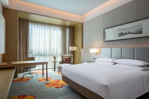 北京北京新青海喜来登酒店				的配有一张床和一张书桌的酒店客房