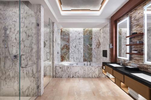 北京北京新青海喜来登酒店				的一间带玻璃淋浴和浴缸的浴室