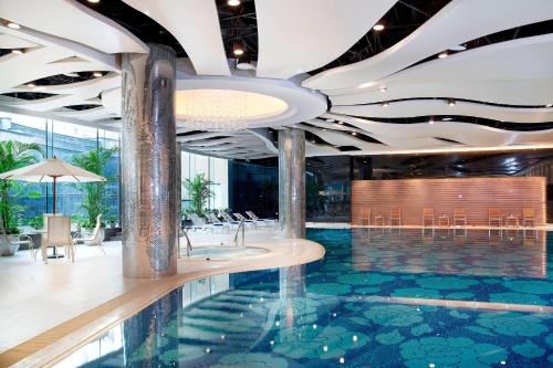 北京北京海淀永泰福朋喜来登酒店的酒店大堂设有游泳池和桌椅