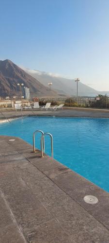 伊基克Hermoso departamento的蓝色的海水和山脉背景的游泳池