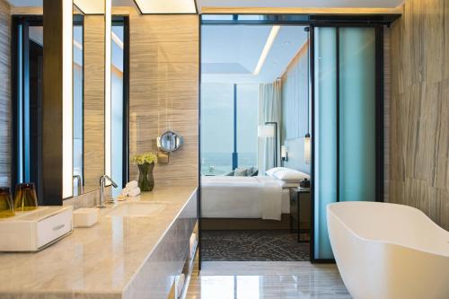 苏州苏州吴江盛虹万丽酒店的一间带床、浴缸和水槽的浴室