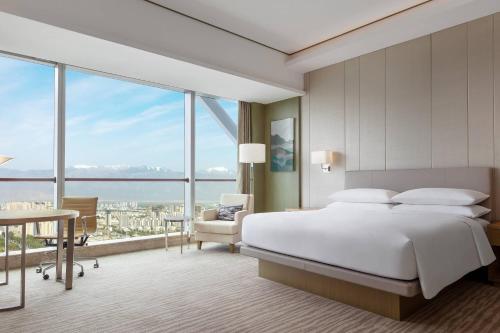 银川银川万怡酒店的一间卧室设有一张床和一个大窗户