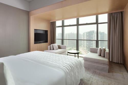 中山中山保利艾美酒店的酒店客房设有一张床和一个大窗户