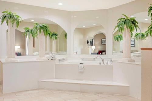 韦克罗斯贝斯特韦斯特普勒斯布拉德伯里旅馆&套房酒店的带浴缸和两棵棕榈树的浴室