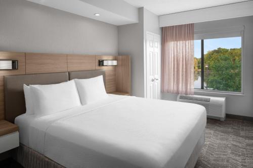 Cascade大瀑布城机场东南万豪斯普林希尔套房酒店的卧室设有一张白色大床和一扇窗户。
