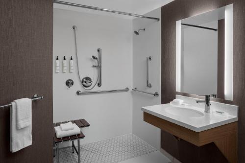 Cascade大瀑布城机场东南万豪斯普林希尔套房酒店的一间带水槽和淋浴的浴室