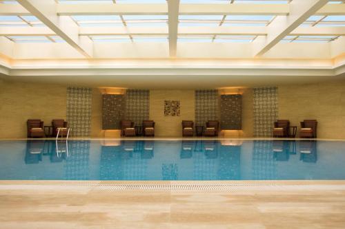 上海上海西藏大厦万怡酒店的大楼内带椅子的大型游泳池