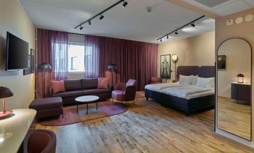 基律纳Scandic Kiruna的酒店客房,配有床和沙发