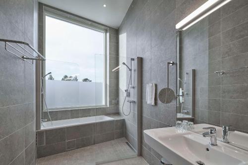 基律纳Scandic Kiruna的一间带水槽、浴缸和淋浴的浴室