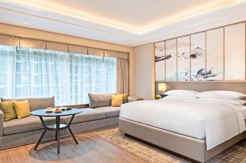 杭州杭州余杭万豪行政公寓的一间卧室配有一张床和一张沙发
