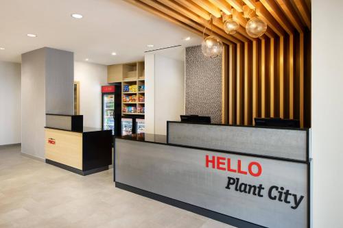 普兰特城TownePlace Suites by Marriott Plant City的商店前方有你好植物城市标志