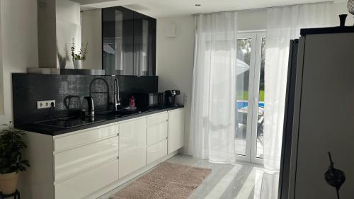 居特斯洛LUXUS-RelaxDays-Apartments的白色的厨房设有水槽和窗户