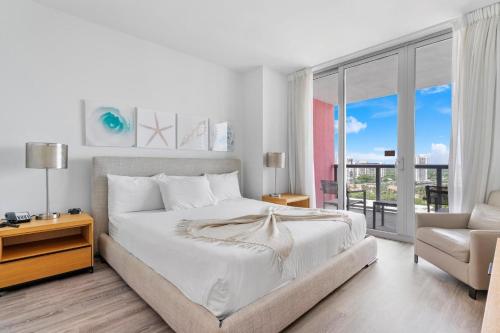 好莱坞Modern two bed Beach Walk Miami 15th的白色卧室配有一张大床和椅子