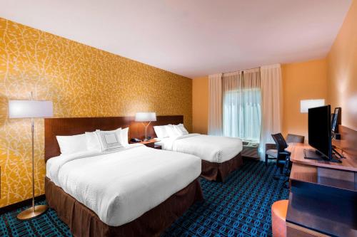 沃克西哈奇Fairfield Inn & Suites by Marriott Dallas Waxahachie的酒店客房设有两张床和一台平面电视。