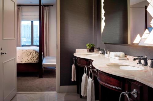 普罗维登斯普罗维登斯市中心万丽酒店的一间带水槽和镜子的浴室以及一间卧室