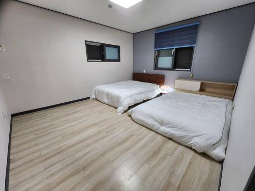 仁川市Unseo Station 10mins - Max 6pax, BBQ的客房设有两张床,铺有木地板。