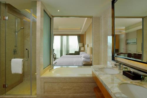 沈阳沈阳新都绿城喜来登酒店的带浴缸、床和镜子的浴室