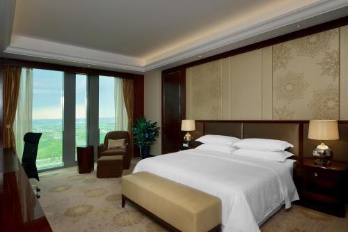 沈阳沈阳新都绿城喜来登酒店的一间卧室设有一张大床和一个大窗户