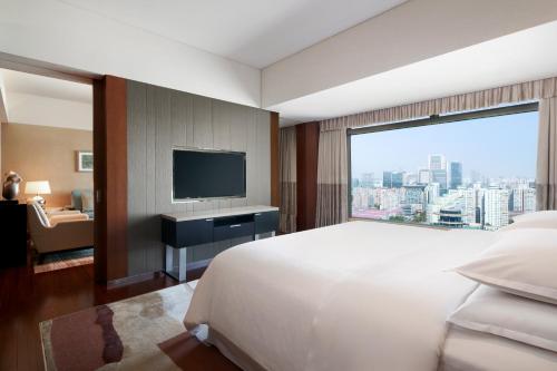 北京北京金隅喜来登大酒店的一间酒店客房,设有一张大床和一个大窗户