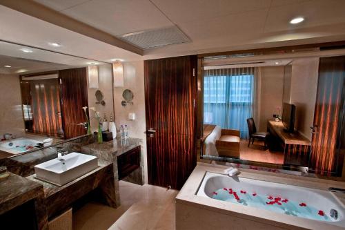 上海上海齐鲁万怡大酒店的浴室配有大浴缸和水槽