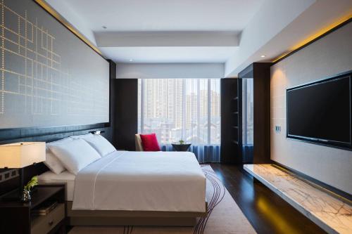 沈阳沈阳太阳狮万丽酒店  的配有一张床和一台平面电视的酒店客房